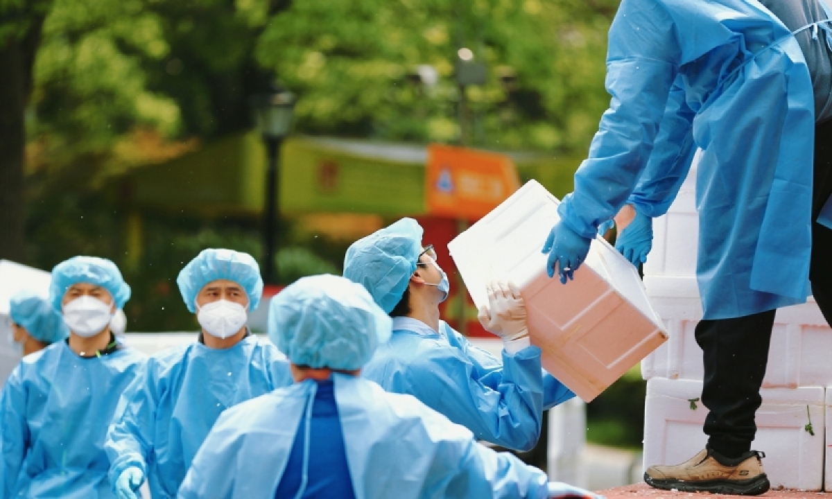 Các tình nguyện viên ở Thượng Hải phân phát hàng hóa cho người dân. Ảnh: VCG