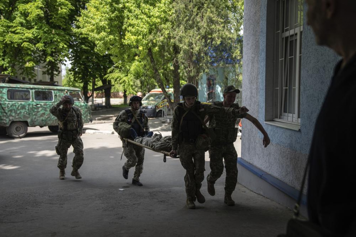 Các binh sỹ Ukraine đang khiêng một người lính bị thương sau một cuộc tấn công tại Donetsk. Ảnh: AP