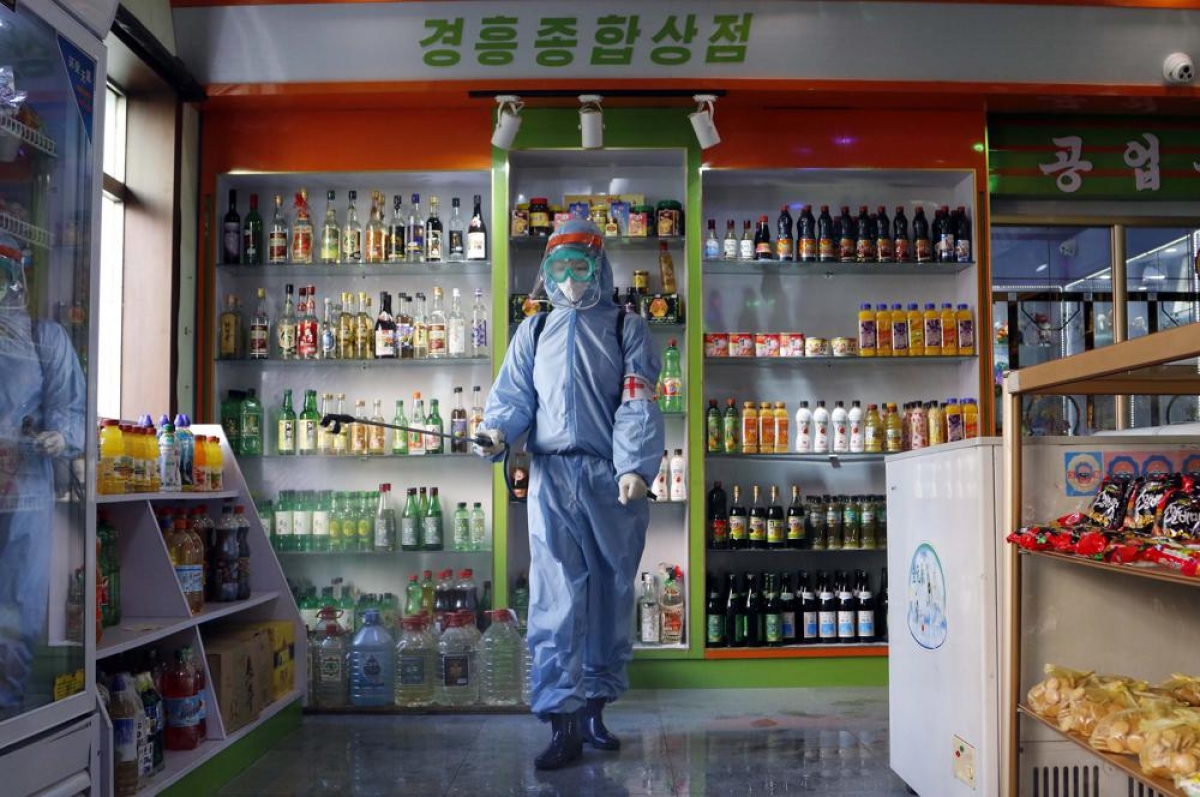 Nhân viên phun khử khuẩn một cửa hàng thực phẩm, đồ uống ở Triều Tiên. Ảnh: AP