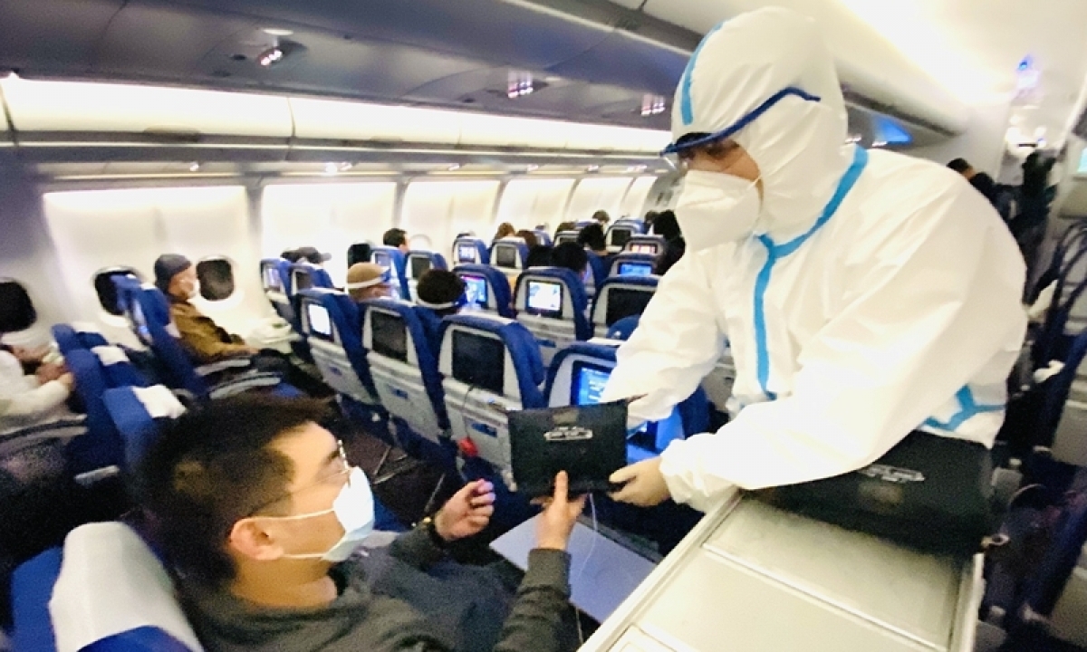 Nhân viên của hãng hàng không Phương Nam (China Southern Airlines) phát bộ dụng cụ phòng chống dịch phiên bản giới hạn cho hành khách trên một số chuyến bay quốc tế đến Trung Quốc. Ảnh: China Southern Airlines