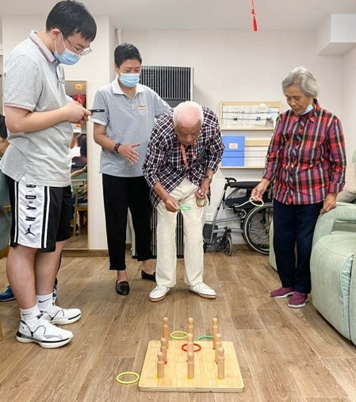 Zhong Zhixiang (giữa) chơi trò ném vòng tại Trung tâm chăm sóc người cao tuổi tích hợp Huayang, Thượng Hải, ngày 20 tháng 8 năm 2021. Ảnh: Sixthtone