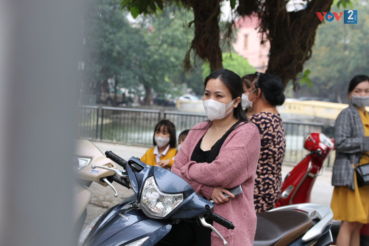 Ngoài cổng trường, nhiều phụ huynh nán lại theo dõi con đi vào lớp.