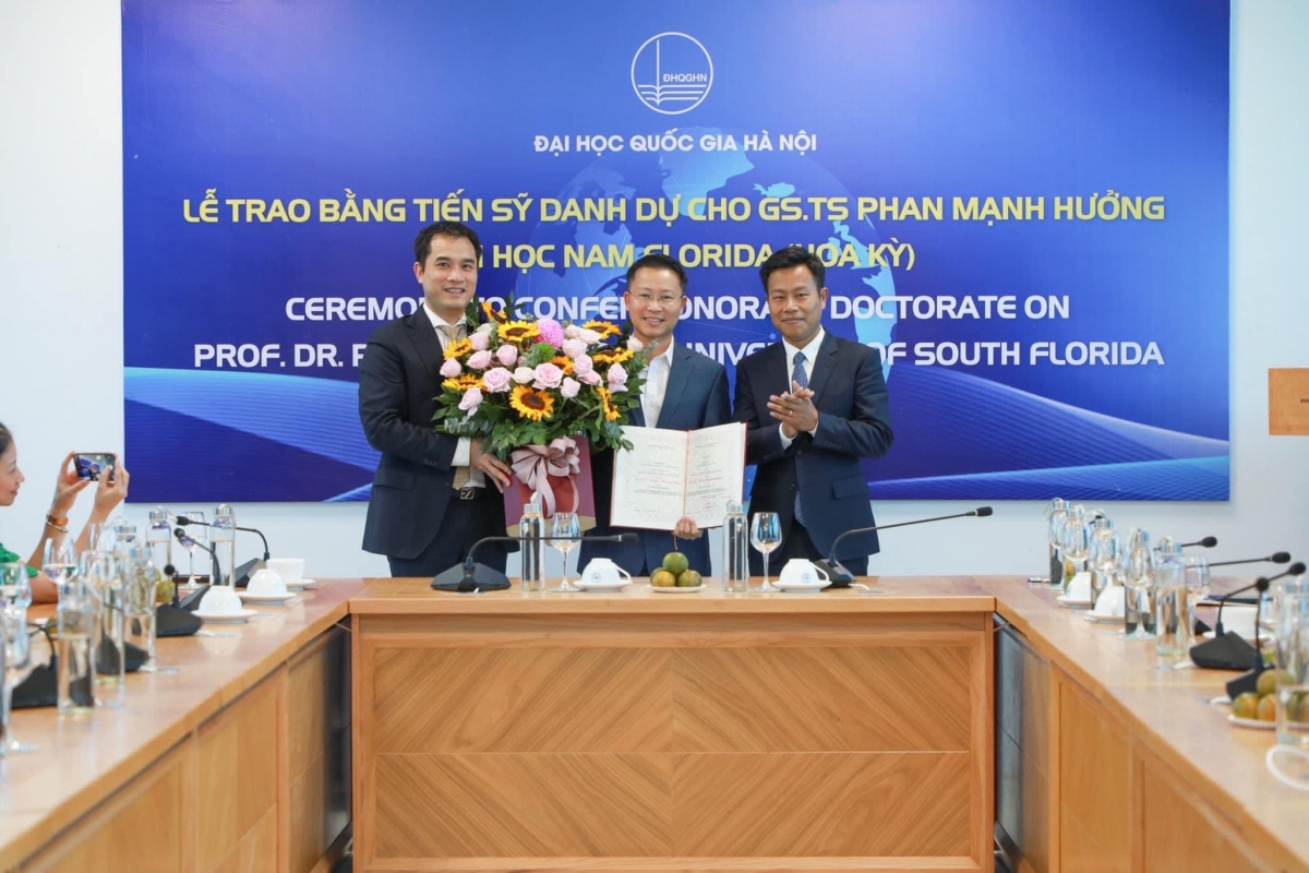 Giám đốc ĐHQGHN GS.TS Lê Quân và PGS.TS Phạm Bảo Sơn- Phó Giám đốc ĐHQG Hà Nội trao bằng Tiến sĩ danh dự và tặng hoa chúc mừng GS.TS Phan Mạnh Hưởng.