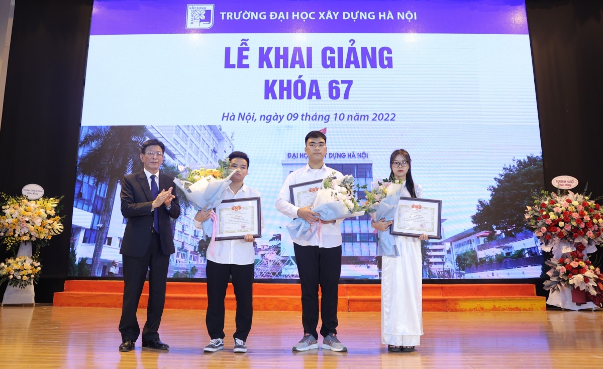 PGSTS NGUT Phạm Duy Hòa, Hiệu trưởng Trường ĐH Xây dựng Hà Nội trao giấy khen và tặng hoa chúc mừng 3 thủ khoa K67 của trường 