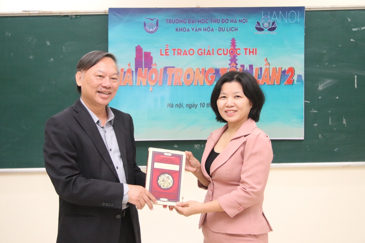 TS. Trịnh Ngọc Ánh, đại diện khoa Văn hóa Du lịch, Trường Đại học Thủ Đô Hà Nội nhận sách về Hà Nội từ GS.TS. NGND Nguyễn Quang Ngọc, góp thêm tư liệu giảng dạy bộ môn Hà Nội học. 