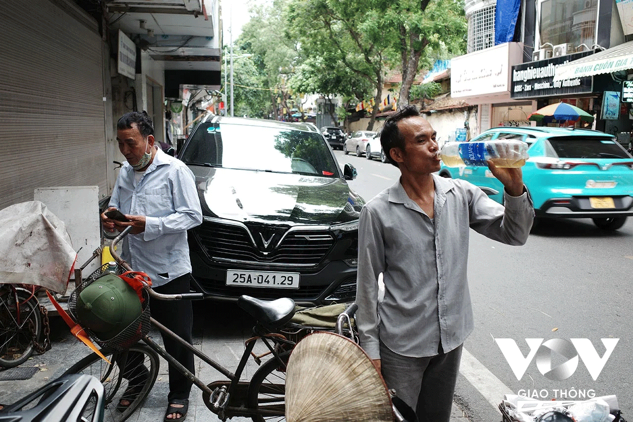 Anh N. và những người "đồng nghiệp" làm nghề thu mua đồ "đồng nát" tranh thủ nghỉ ngơi, nắng nóng khiến họ phải liên tục tiếp nước nếu không sẽ rất nhanh xuống sức.