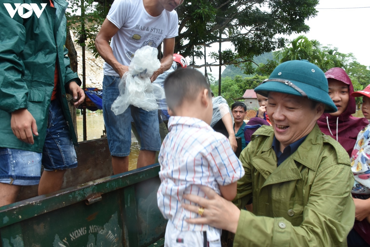 Bí thư huyện ủy Lục Yên hỗ trợ người dân đưa trẻ đến trường.