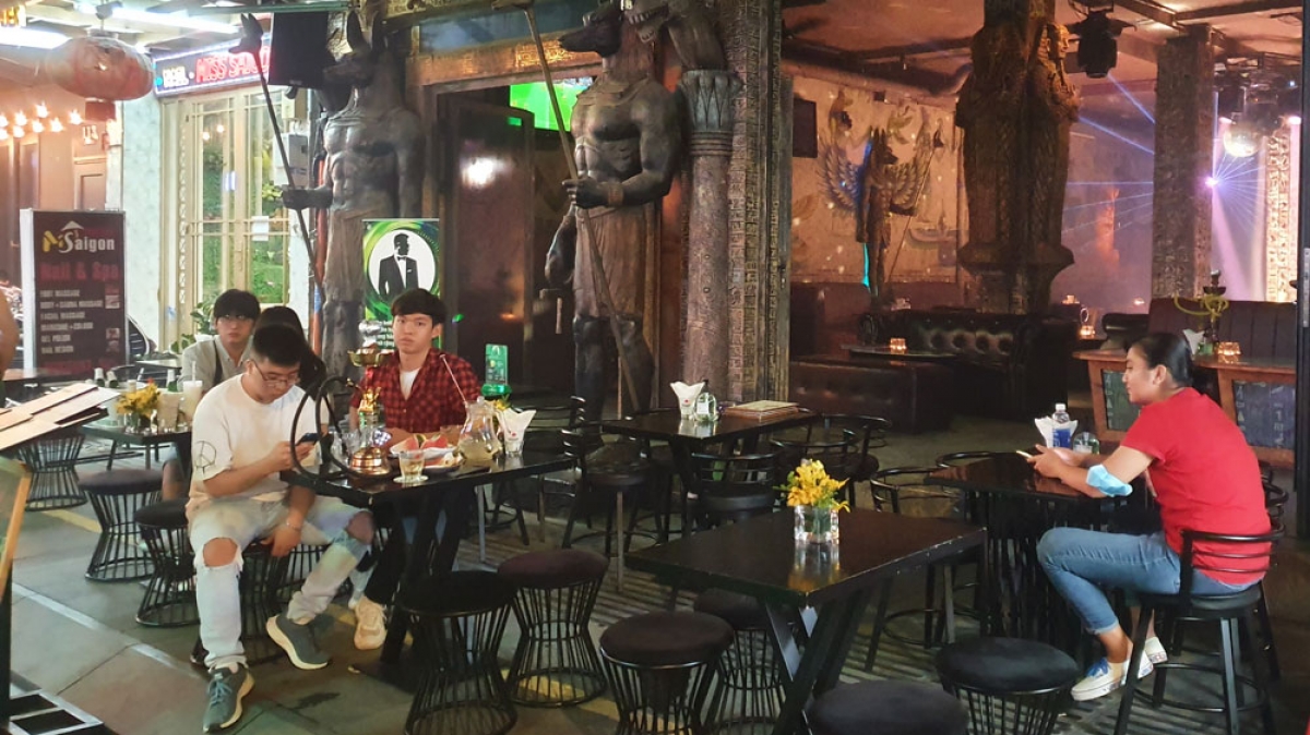 Bên ngoài một quán bar, lác đác có vài vị khách