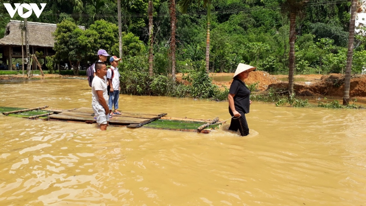 Người dân dùng tre và gỗ làm mảng vận chuyển học sinh đến lớp ở thôn Làng Quỵ, xã Minh Tiến.