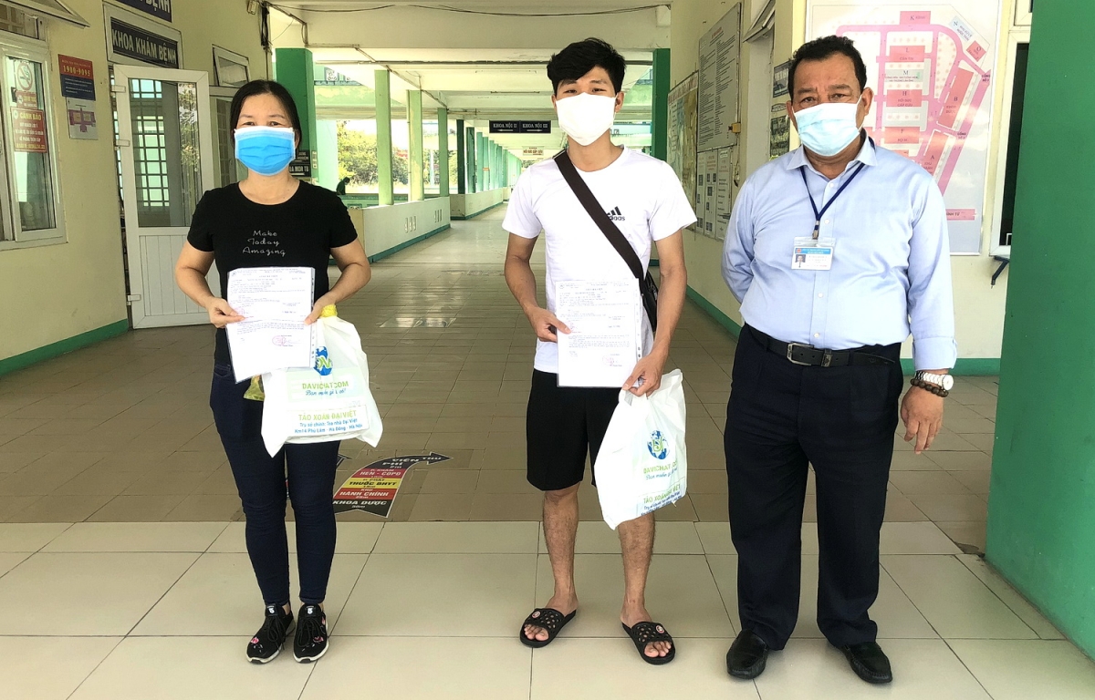 Bác sĩ Lê Thành Phúc (ngoài cùng bên phải) trao giấy ra viện cho 2 bệnh nhân.