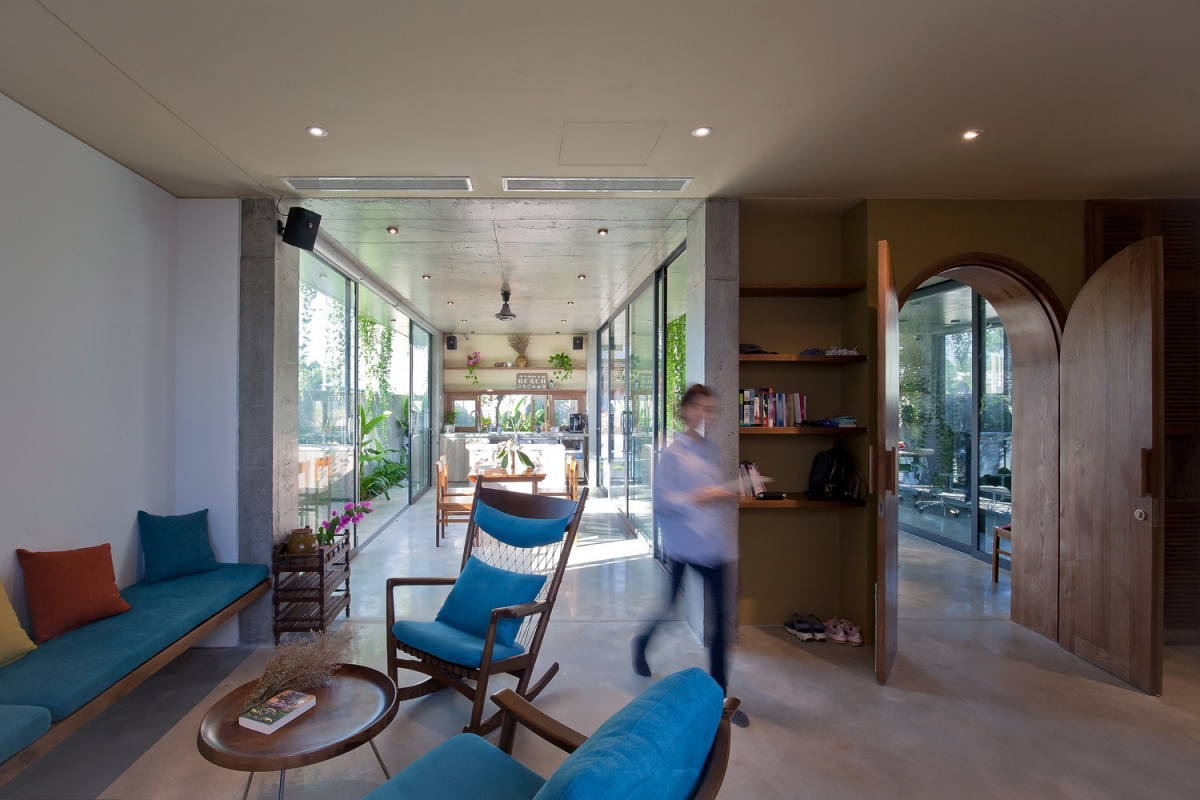 Phòng khách giản dị với bộ bàn ghế sofa gỗ, nệm bọc màu xanh mang đến không khí yên bình, dễ chịu.