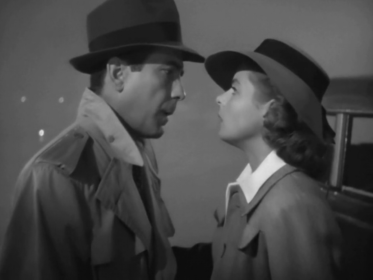 Trang phục của Humphrey Bogart trong Casablanca (1942): Trong Casablanca, Rick Blaine (Humphrey Bogart) là một chủ quán bar đã dang tay cứu giúp tình cũ Ilsa (Ingrid Bergman) và chồng cô trên hành trình tị nạn chiến tranh. Cuối phim, dù vẫn còn yêu, Rick đã thúc giục Ilsa chạy trốn cùng chồng dưới cơn mưa tầm tã. Trang phục của Rick, với chiếc áo khoác màu be và chiếc mũ phớt rộng vành, đã trở thành một hình ảnh biểu tượng của điện ảnh thế giới cũng như câu thoại của anh khi ấy: “Chúng ta sẽ luôn có Paris”. Ảnh: Outnow.