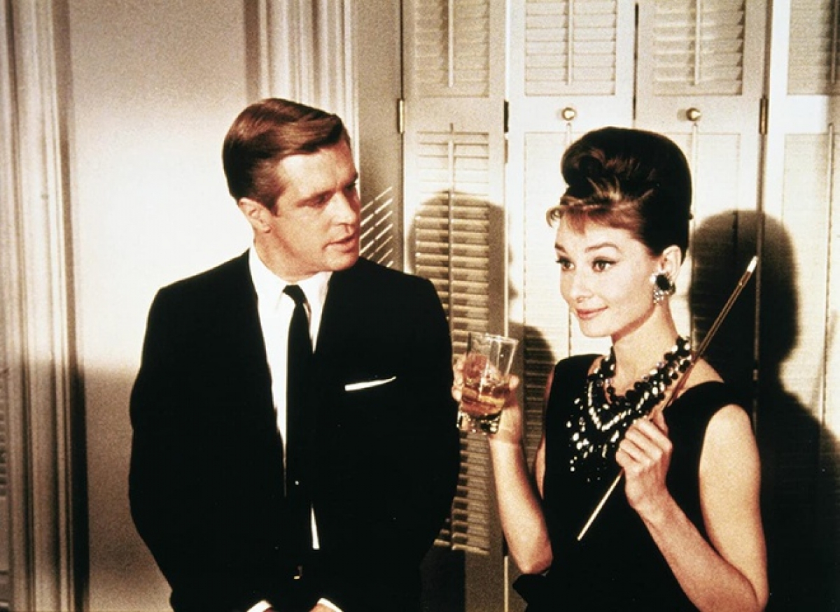 Trang phục của Audrey Hepburn trong Breakfast at Tiffany’s (1961): Breakfast at Tiffany’s là sàn diễn thời trang của Audrey Hepburn. Nhân vật do minh tinh thủ vai liên tục diện những bộ cánh mới trên màn ảnh, ngầm ám chỉ xuất thân thượng lưu của cô. Trong số đó, chiếc váy đen Hepburn mặc trong cảnh mở đầu phim đã đi vào lịch sử. Tới tận ngày hôm nay, chiếc váy đen của nhà mốt Hubert de Givenchy vẫn được liệt vào danh sách những món đồ thời trang thiết yếu. Ảnh: Jurow-Shepherd.