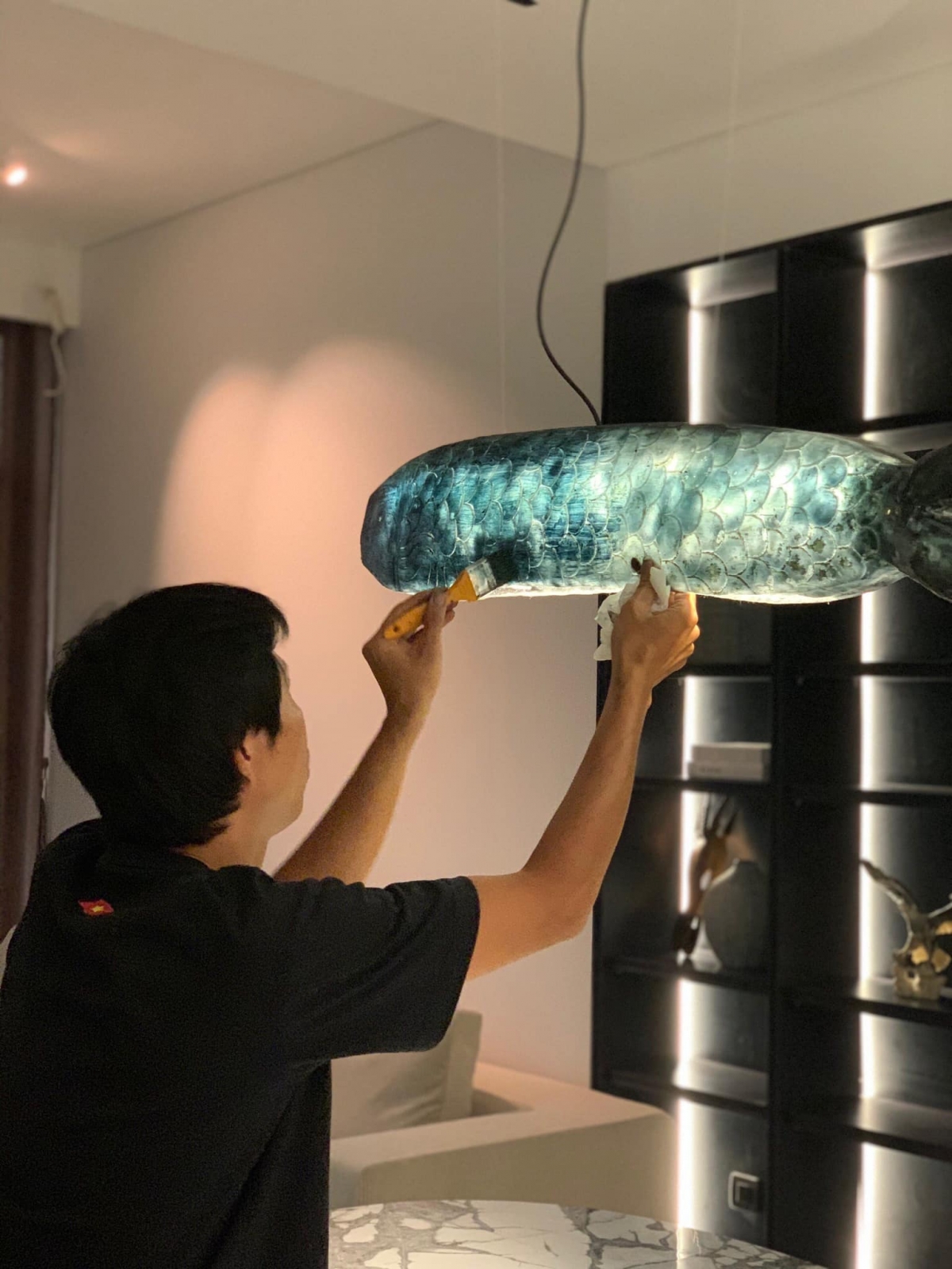 Chị Hà Linh thay đèn trang trí ở bàn ăn bằng đèn làm của nghệ sĩ đèn để cân bằng lại phong cách tối giản - có phần hơi lạnh của căn nhà.