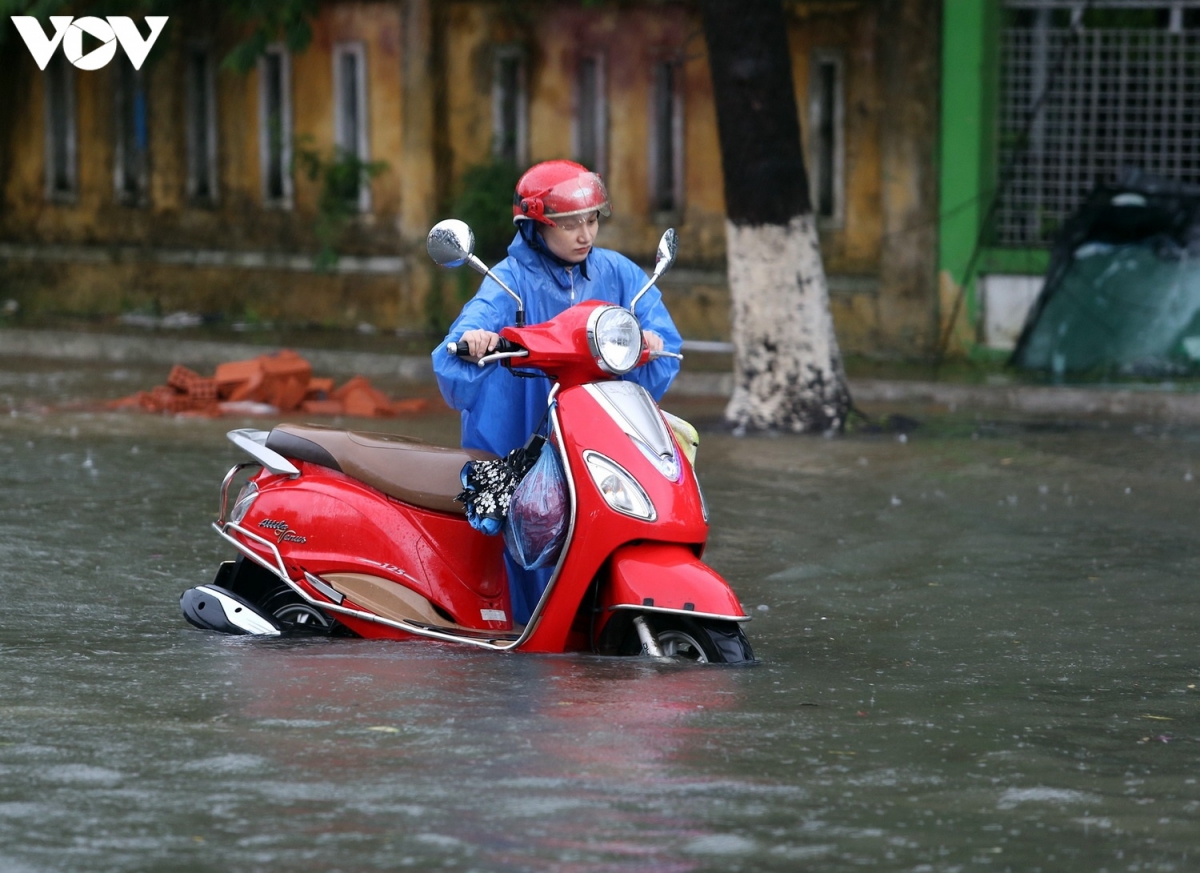 Nhiều người dân gặp khó khi nhiều tuyến đường tại thành phố Tam Kỳ ngập cục bộ. (Ảnh: Xe chết máy giữa trời mưa).