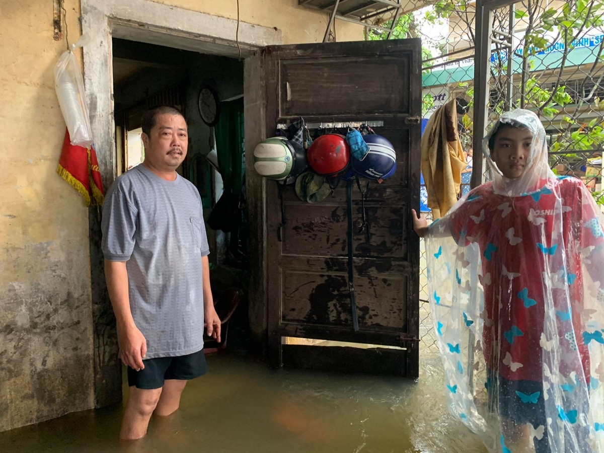 Anh Lê Văn Sơn, ở thôn Thủy Phú, xã Hương Vinh, thị xã Hương Trà dọn dẹp đồ đạc khi nước vào nhà.