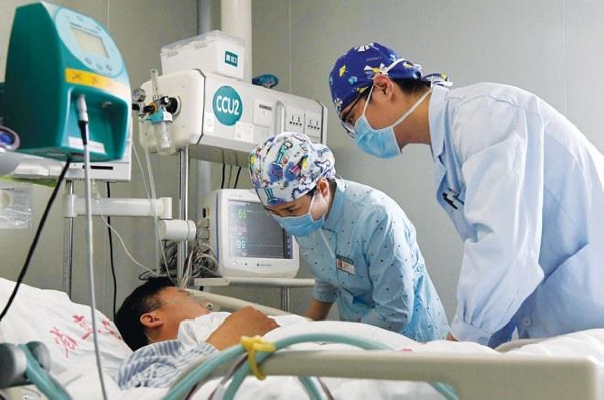 Nhân viên y tế chăm sóc bệnh nhân tại bệnh viện ở Trung Quốc. Ảnh: SINA.