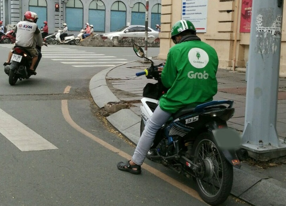 Có khá nhiều bạn trẻ lựa chọn việc làm xe ôm là công việc chính. (Ảnh: báo Lao Động)