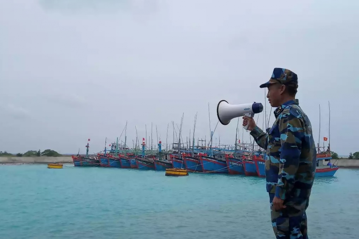 Cán bộ âu tàu Song Tử Tây hướng dẫn tàu cá vào âu tránh bão. 