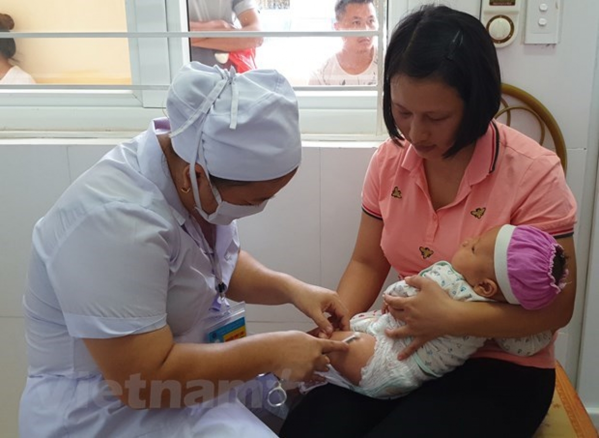 Nhân viên y tế tiêm chủng cho trẻ nhỏ. (Ảnh: TTXVN)