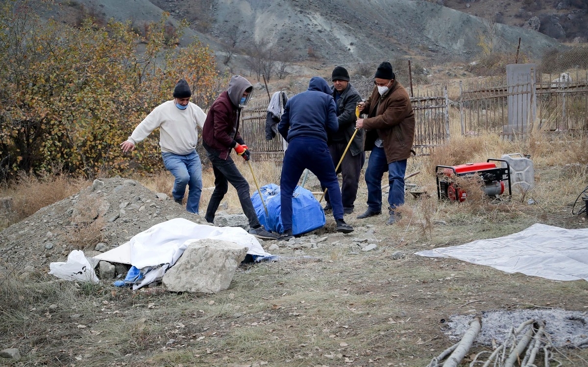 Người tộc Armenia sinh sống ở vùng phải giao cho Azerbaijan đang khênh quan tài của người thân họ (vừa khai quật từ mộ) để đưa sang Armenia. Một bộ phận người Armenia ở vùng lân cận Nagorno-Karabakh đã đào hài cốt tổ tiên của mình để đưa đi trước khi các lãnh thổ họ sinh sống được chuyển giao cho Azerbaijan. Ảnh: AP.