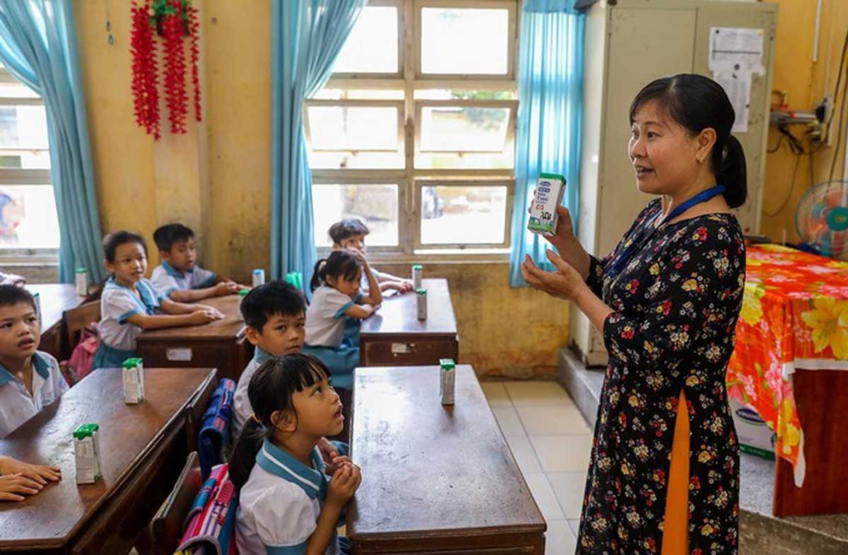 Giáo viên trường Tiểu học Thị trấn Củ Chi (TP HCM) hướng dẫn cho học sinh uống sữa học đường đúng cách vào tháng 6/2020.