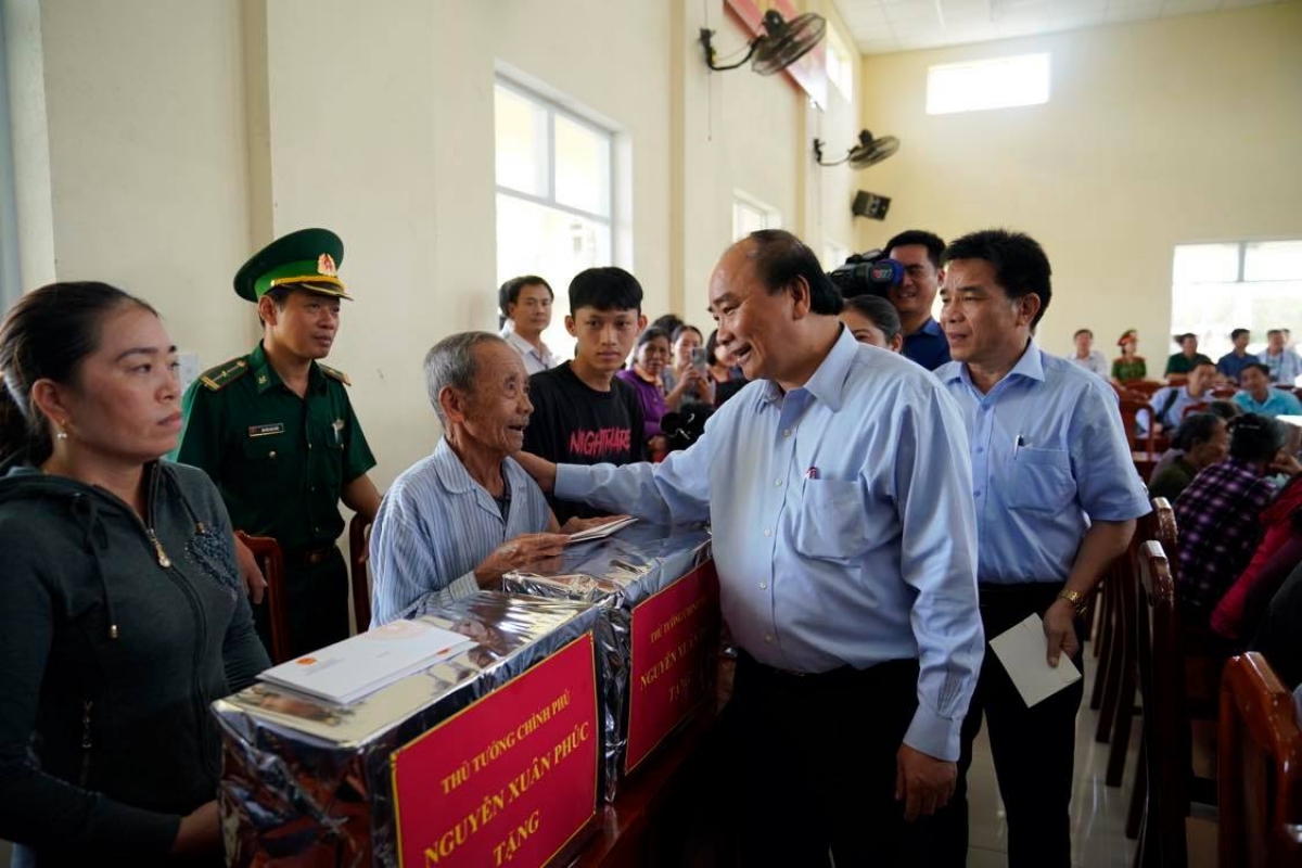 Thủ tướng Nguyễn Xuân Phúc động viên bà con xã Tam Quang, huyện Núi Thành, Quảng Nam đoàn kết, giúp đỡ, hỗ trợ nhau vượt qua khó khăn, sớm trở lại cuộc sống bình thường sau thiên tai. Ảnh VGP/Quang Hiếu