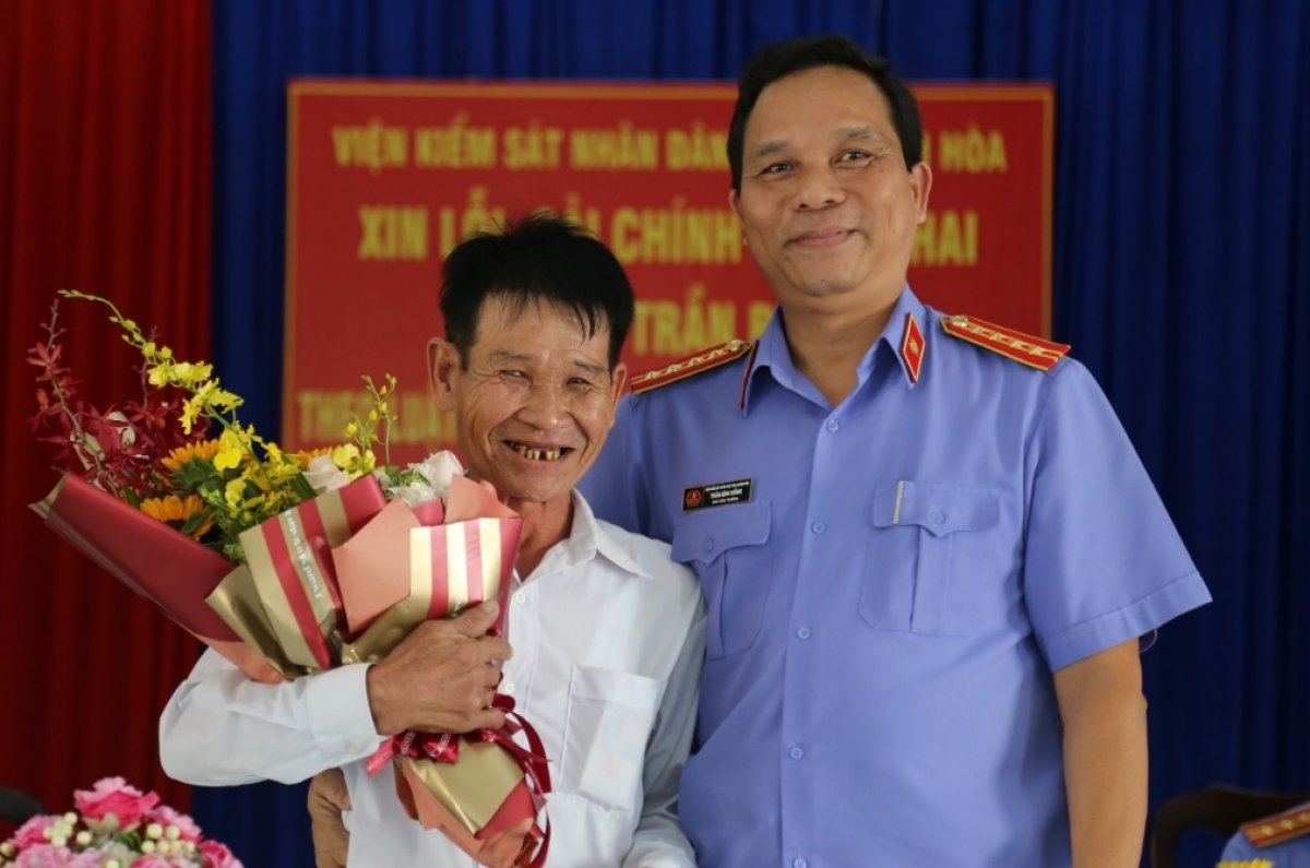 Ông Trần Bê (bên trái cầm hoa)
