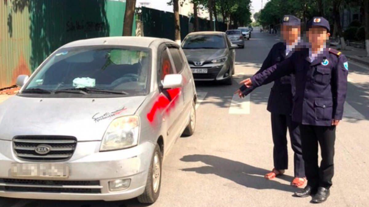 Nhóm bảo vệ xịt sơn đỏ lên xe ô tô.