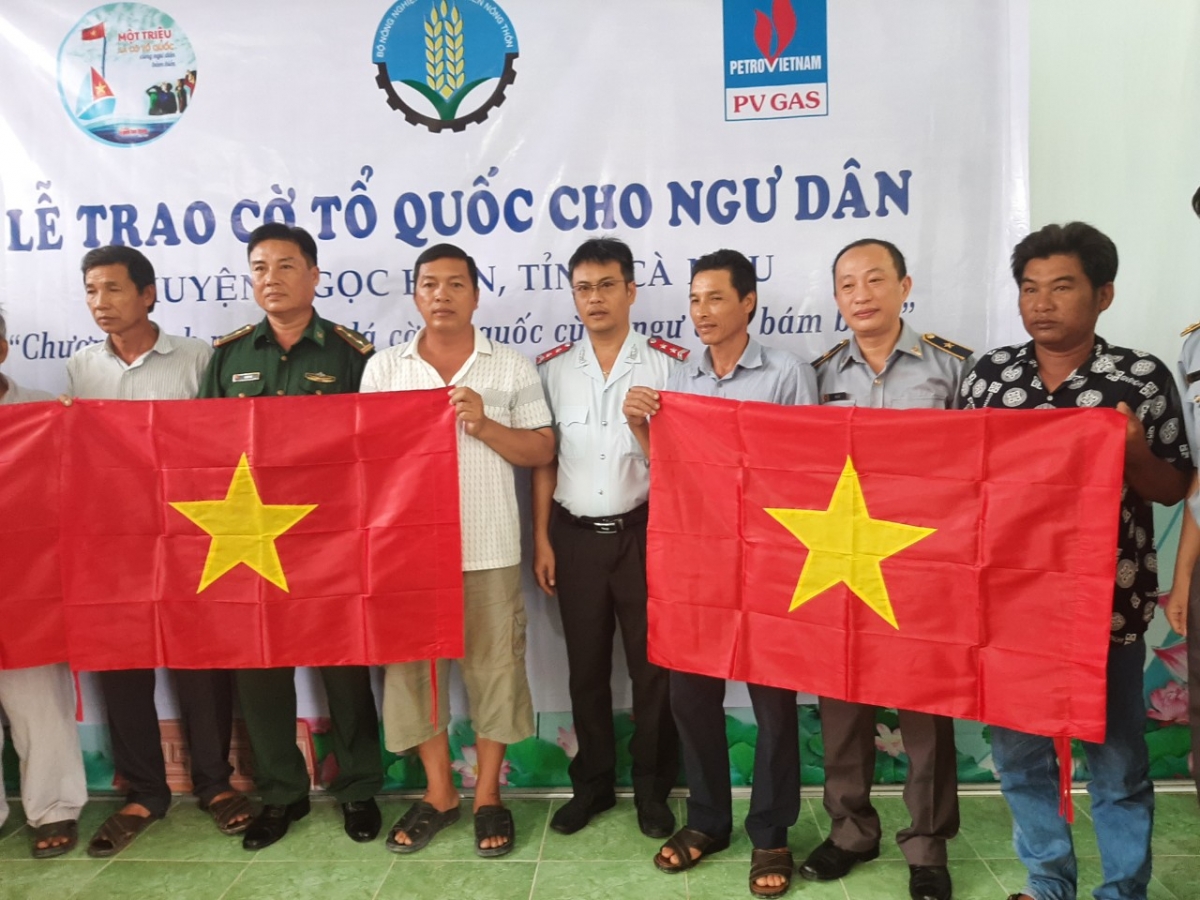 Ông Hà Lê (thứ 2 từ phải sang) Phó Cục trưởng Cục Kiểm ngư cùng lãnh đạo địa phương trao cờ cho ngư dân Ngọc Hiển. (Ảnh: Đình Trọng - Cục Kiểm ngư)