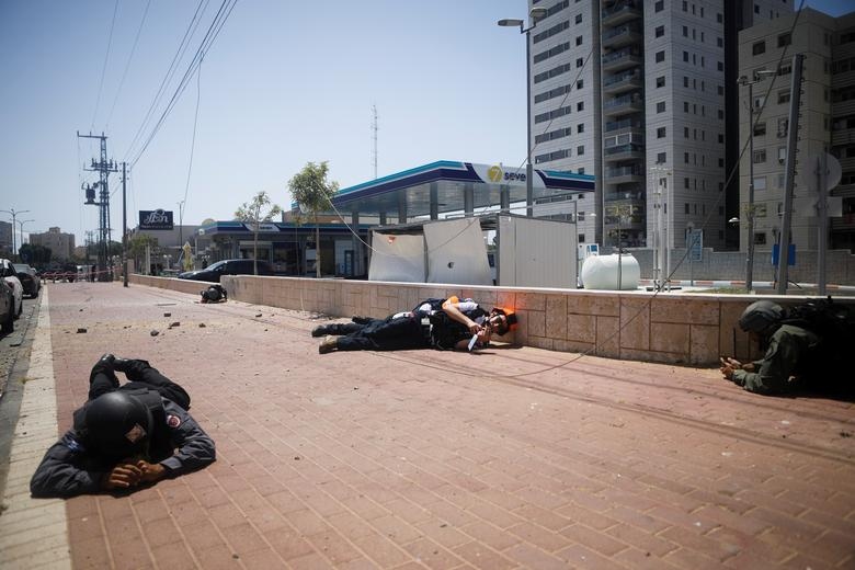 Người Israel ẩn nấp trong một lần Hamas phóng rocket từ Gaza sang. Ảnh: Reuters.