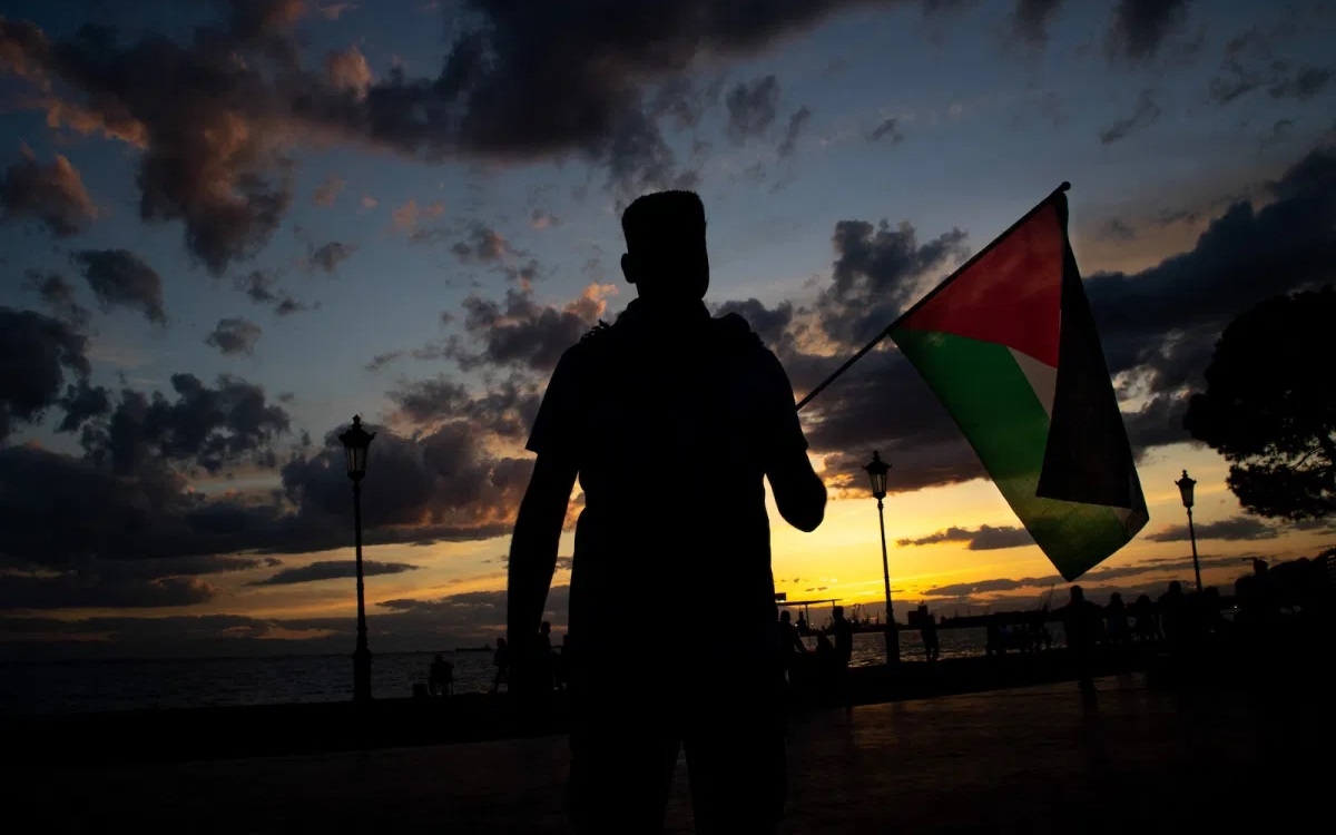 Một nam giới Palestine cầm cờ Palestine. Ảnh: NurPhoto.