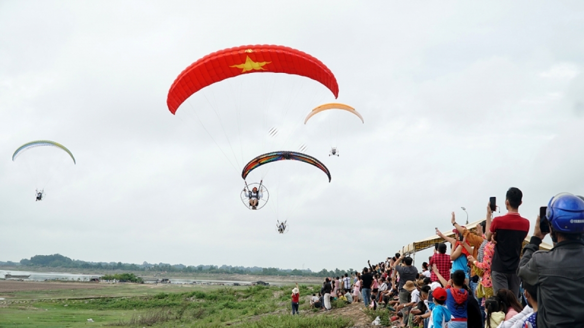 Đông đảo người dân và du khách xem biểu diễn dù lượn (ảnh Đ.D).