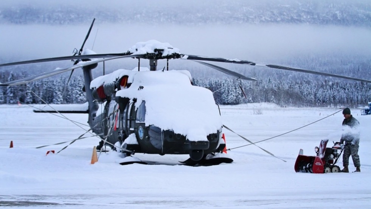 Lực lượng Vệ binh Quốc gia của Quân đội Alaska dọn tuyết xung quanh trực thăng UH-60 Black Hawk tại Căn cứ Liên hợp Elmendorf-Richardson. Ảnh: Alaska National Guard Public Affairs