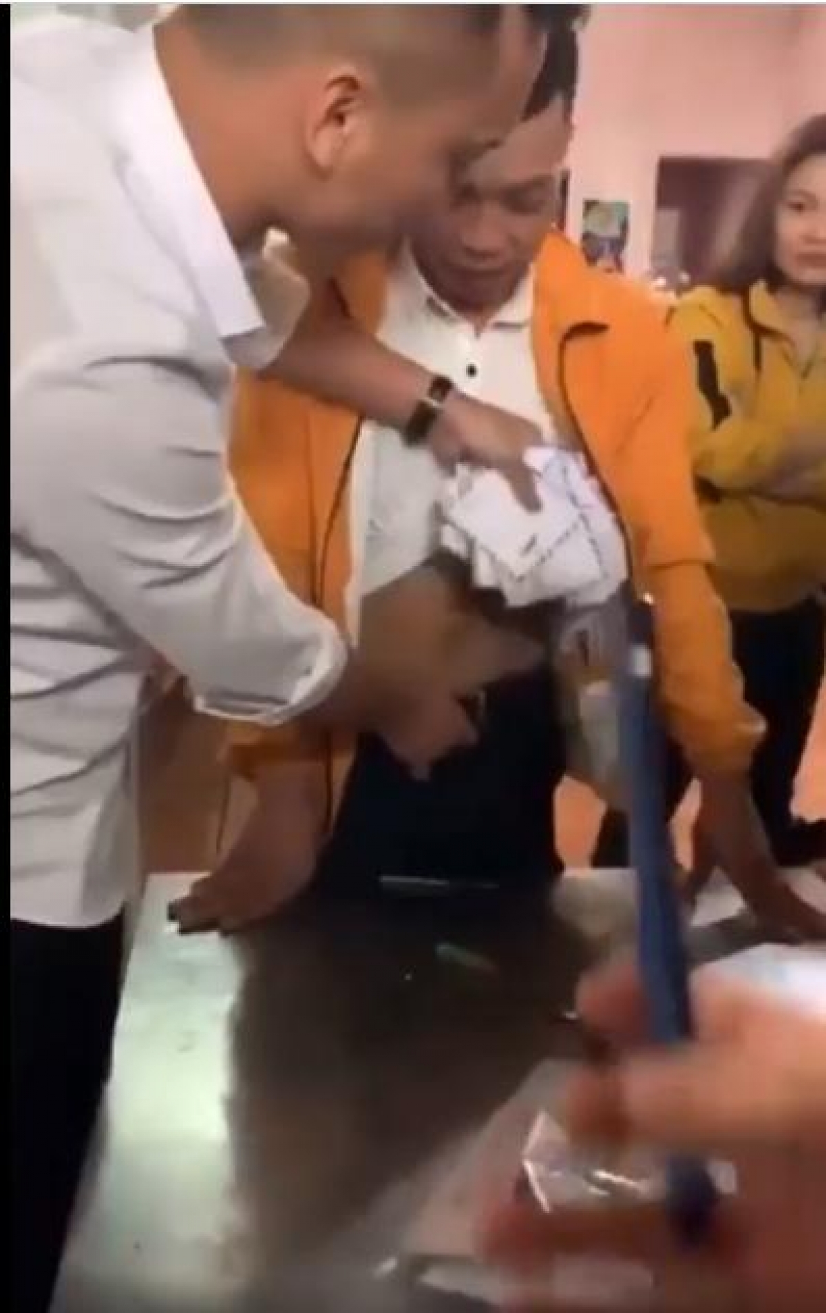 Người nhà bà Huệ lôi số phong bì bị giấu trong quần Giang.