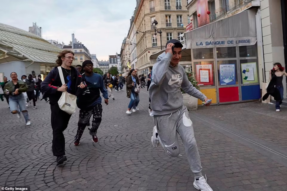 Người dân chạy qua các phố trung tâm của Paris ngay sau khi hay tin Tổng thống Macron tái đắc cử. Ảnh: Getty.