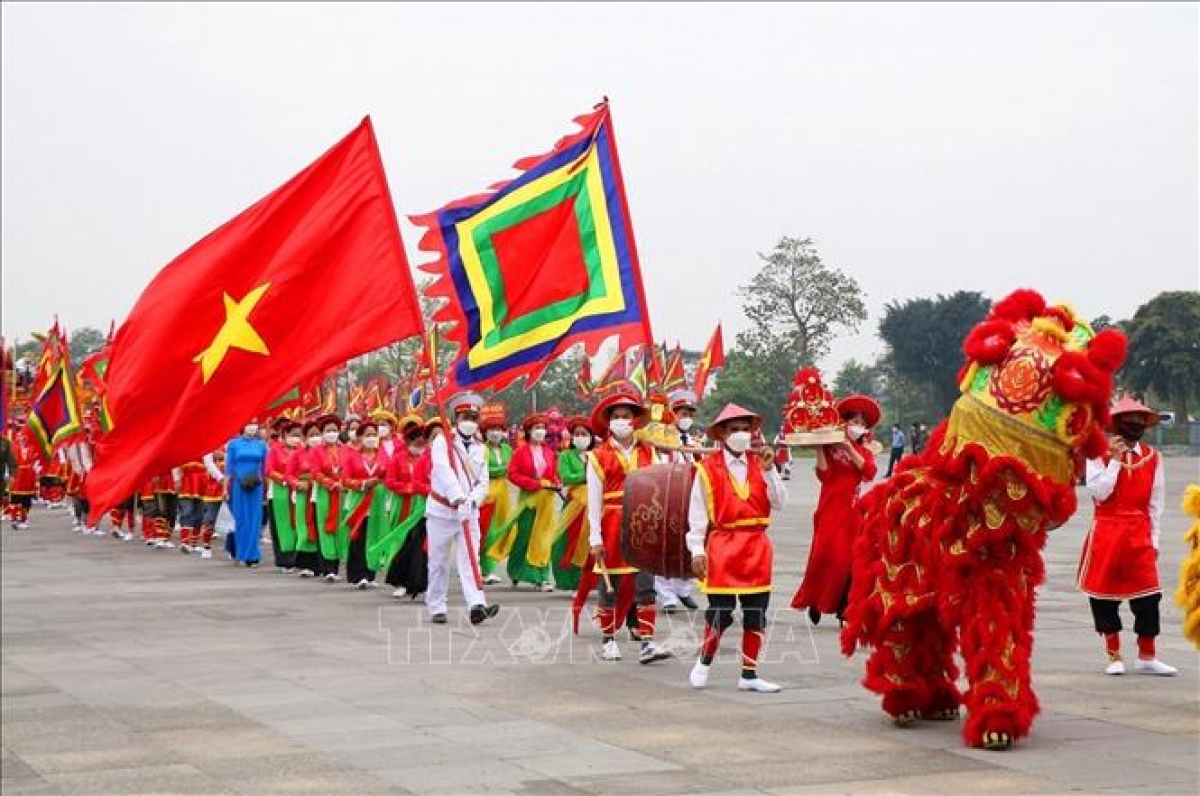 Đi đầu đoàn rước kiệu là đội múa Lân, sư tử, Quốc kỳ và cờ lễ. Ảnh: Trung Kiên/TTXVN