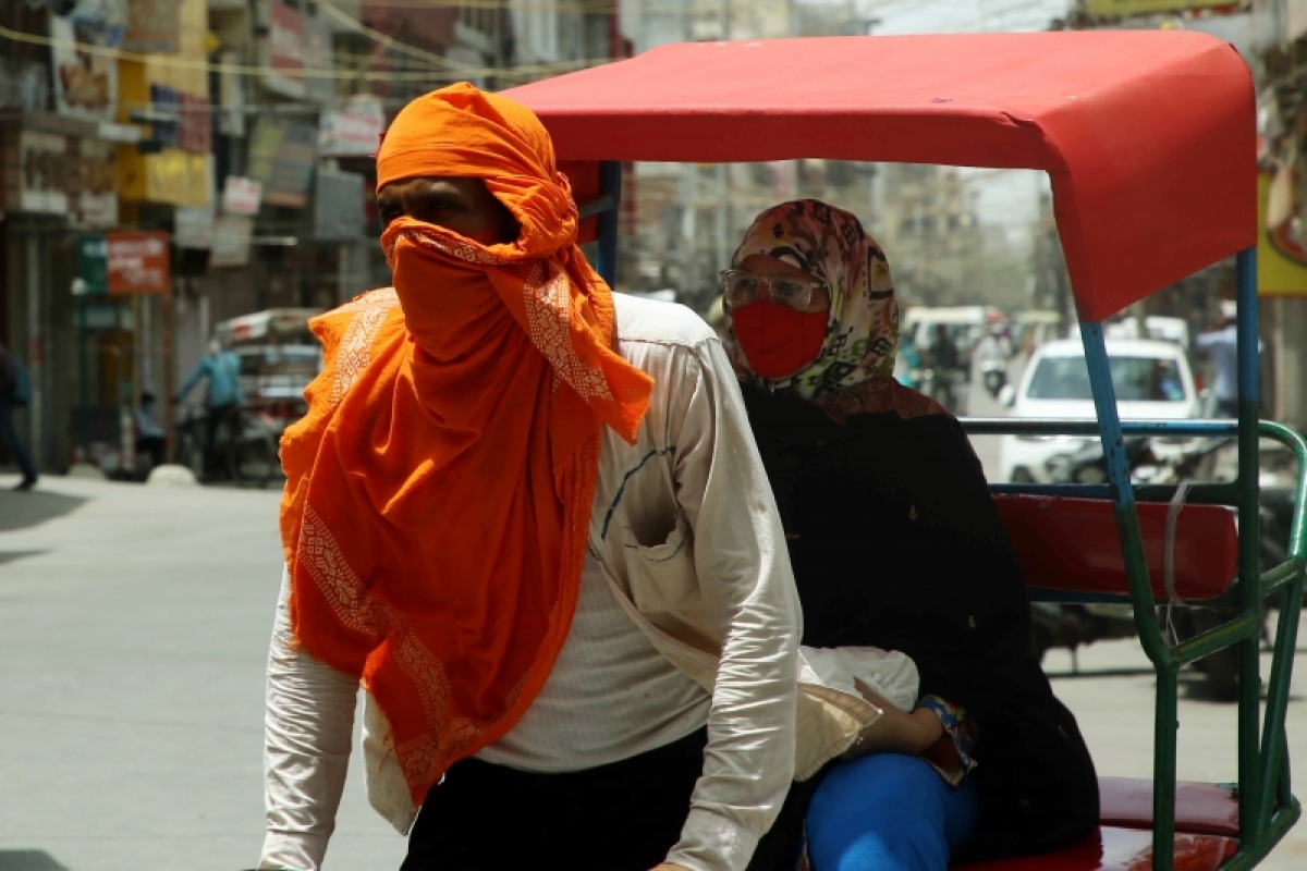 Một người lái xe tuk tuk tại thủ đô New Delhi quấn khăn để tránh hơi nóng lên tới 44 độ C. (Ảnh: ANI)