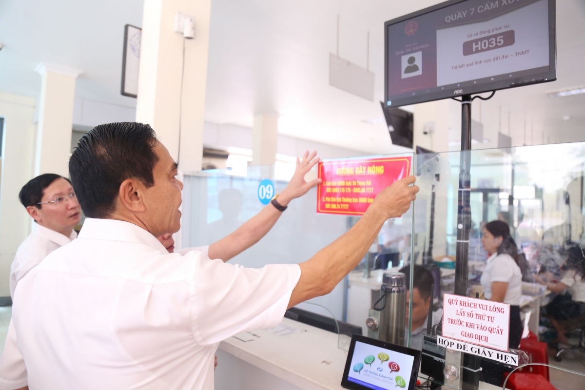 Chủ tịch tỉnh Hà Tĩnh gắn số điện thoại đường dây nóng. Ảnh: Vietnamnet