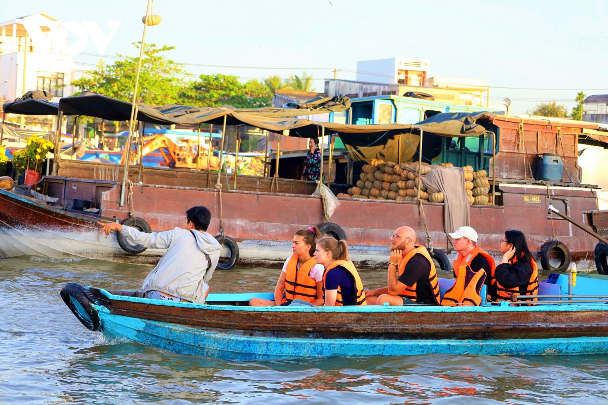 Foreign visitors are eager to explore the dailylife activity of local people in Can Tho during a tour of Cai Rang floating market.