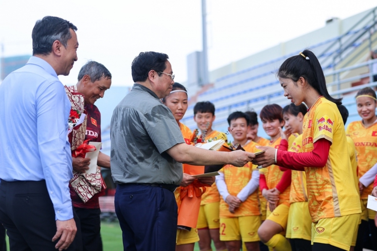 Prime Minister Pham Minh Chinh presents gifts to the coaching board and female footballers ahead of their World Cup campaign in New Zealand and Australia. (Photo: VGP)