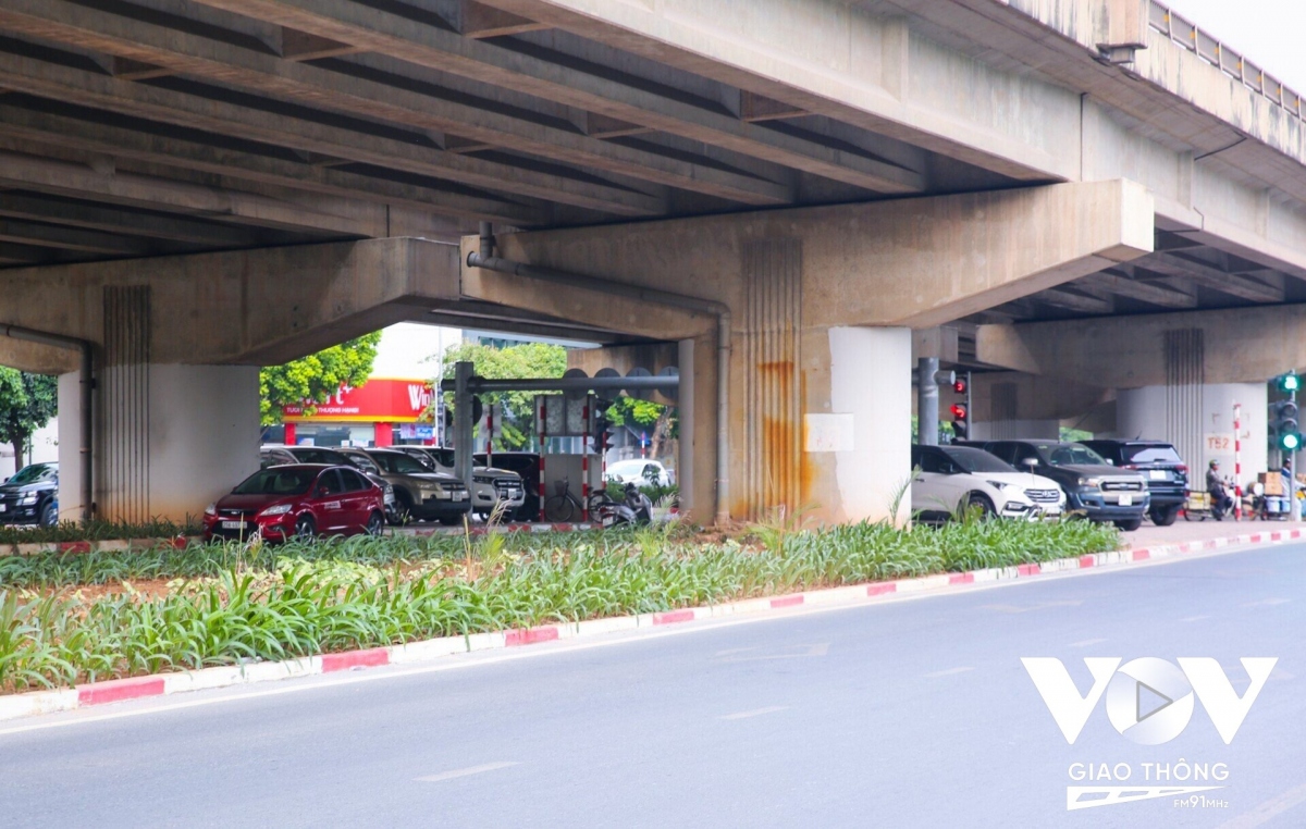 Khu vực đầu cầu được tận dụng trở thành nơi đỗ xe, thậm chí một số phương tiện còn đỗ dưới lòng đường. (Ảnh: Lê Tùng)