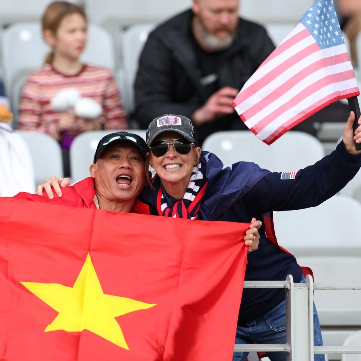 A Vietnamese fan poses for a group photo alongside an American fan.