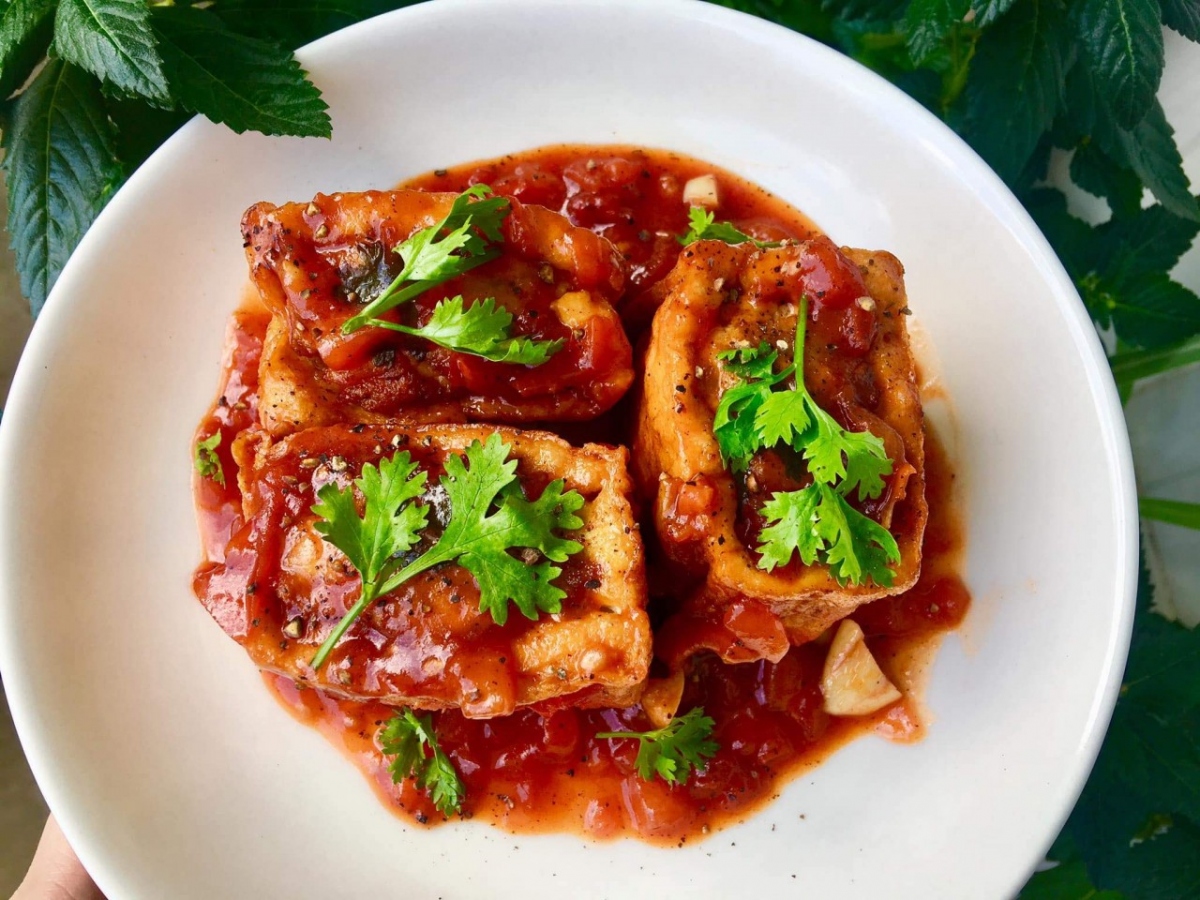 Đậu sốt cà chua (stir-fried tofu in tomato sauce) is a dish that evokes childhood memories in most Vietnamese homes. The deep-fried tofu is left marinated in a silky homemade tomato sauce and is both comforting and flavourful. It is best enjoyed with a bowl of steamed rice, which perfectly soaks in the various textures and flavours.