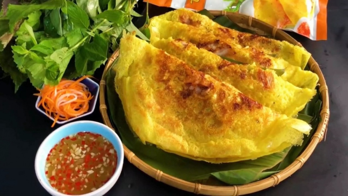 Bánh xèo (rice flour pancake) is made using a blend of rice flour, turmeric, and coconut milk. The pancake is traditionally cooked in a large skillet, sizzling, and crackling as it hits the hot oil, the sounds add to the anticipation. It’s then topped with aromatic herbs like mint and perilla leaves.