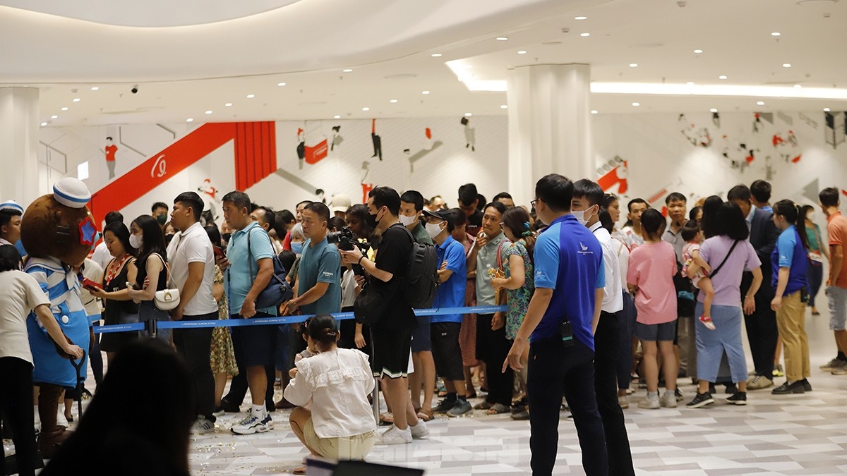 Visitors queue in long lines as they wait to purchase entrance tickets on the first day of the aquarium opening.
