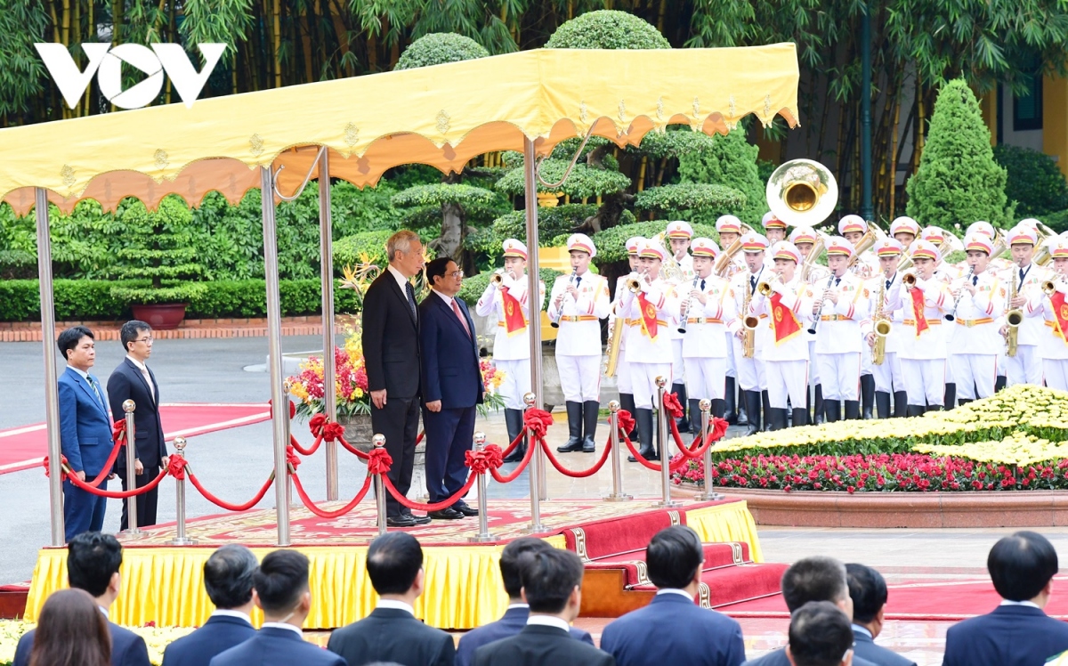 Hai Thủ tướng đứng trên bục danh dự, quân nhạc cử quốc thiều hai nước. 