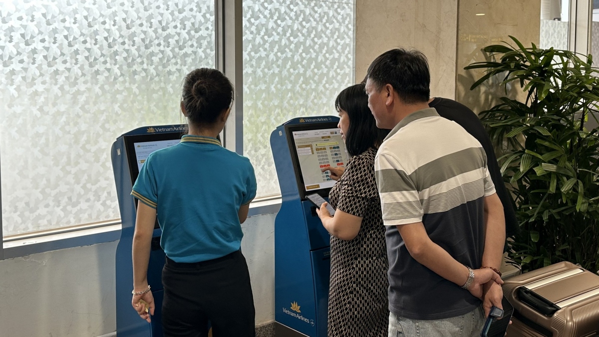 Nhân viên sân bay hướng dẫn khách check in online (Ảnh: C.Linh)