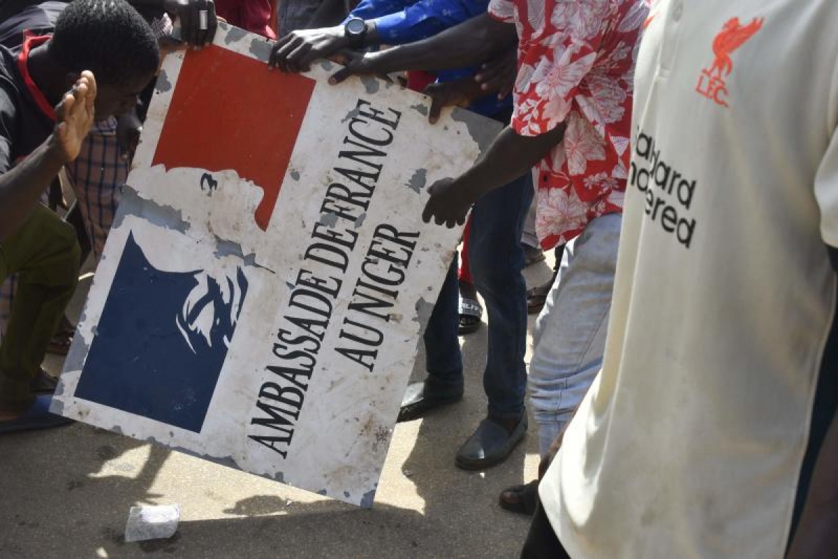 Những người biểu tình với tấm bảng lấy từ Đại sứ quán Pháp ở Niamey (Ảnh: Reuters).