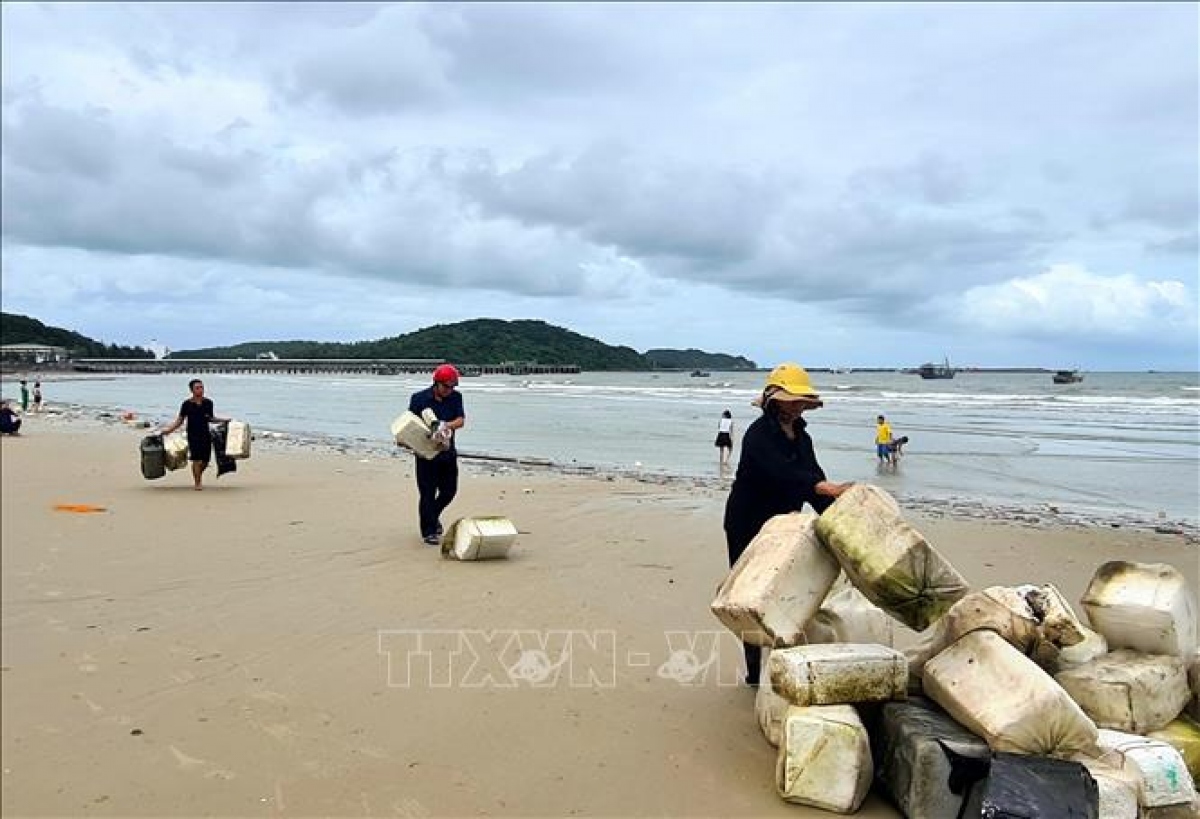 Cán bộ, nhân dân Cô Tô nhanh chóng thu dọn phao xốp trôi dạt vào từ vùng biển lân cận (Ảnh: TTXVN)